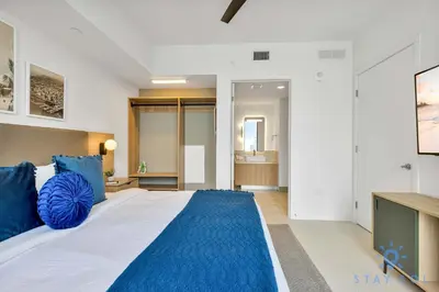 a bedroom with a large bed with blue pillows at Modern 1BR Apartment with Pool in Miami