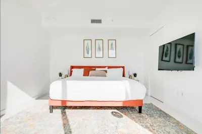 a white bedroom with a bed and a rug at Miami Paraiso- Rooftop pool views and prime location in Miami