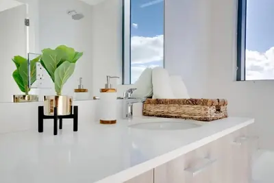 a bathroom counter with a sink and a basket of towels at Miami Paraiso- Rooftop pool views and prime location in Miami