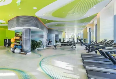 a gym with rows of exercise equipment in a building at Miami Paraiso- Rooftop pool views and prime location in Miami