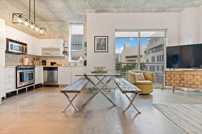 a living room with a table and a couch and a kitchen at City Loft - Downtown Bayfront pool gym & parking in Miami