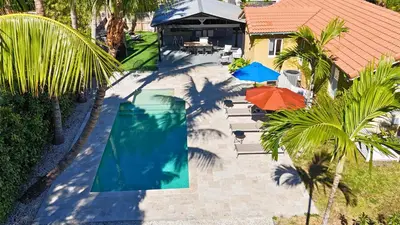 an overhead view of a swimming pool next to a house at Heated Pool Tropical House with Summer Kitchen 3BR- Oasis in Miami! in Miami