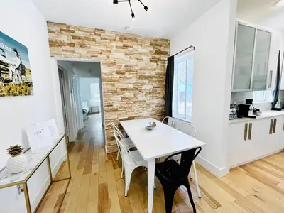 a kitchen and dining room with a white table and chairs at Heated Pool Tropical House with Summer Kitchen 3BR- Oasis in Miami! in Miami