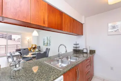a kitchen with a sink and a living room at Spacious 29th Floor 1 BED 1 BTH Brickell Ocean View in Miami