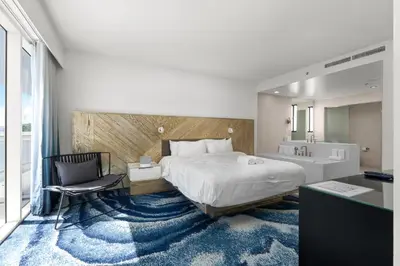 a bedroom with a bed and a desk and a chair at 2BR W Residence FLL, OCEAN VIEWS, Infinity pool, hot tub, large balcony, easy amentiy access in Fort Lauderdale