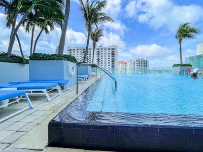 a swimming pool on the roof of a building with palm trees at 2BR W Residence FLL, OCEAN VIEWS, Infinity pool, hot tub, large balcony, easy amentiy access in Fort Lauderdale