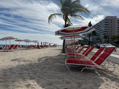 a group of chairs and umbrellas on a beach at 2BR W Residence FLL, OCEAN VIEWS, Infinity pool, hot tub, large balcony, easy amentiy access in Fort Lauderdale