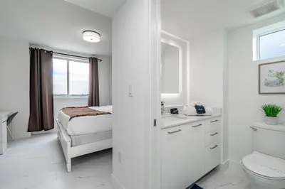 a white bathroom with a bed and a sink at Stylish Apt with Pool and Gym near beach in Hollywood