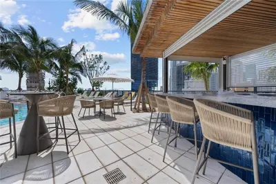 a patio with chairs and a bar with a view of the ocean at La Terrasse by VIAC - Luxury Bay View Studio with Balcony 29th Floor Miami in Miami