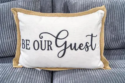 a pillow that says be our guest on a couch at Casa Roselle # 2 in Hollywood