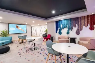 a waiting room with tables and chairs and a large screen at Stylish Downtown Miami Getaway 30th Story View in Miami