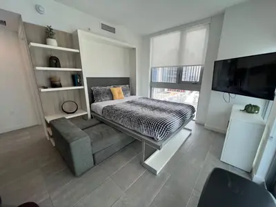 a room with a bed and a couch and a tv at Stylish Downtown Miami Getaway 30th Story View in Miami