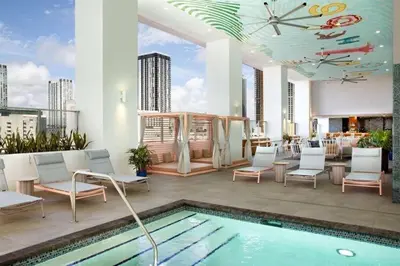 a swimming pool with white chairs and a building at Stylish Downtown Miami Getaway 30th Story View in Miami