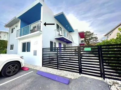 a white house with a black fence and a car at Newly Remodeled full Apartment in Miami