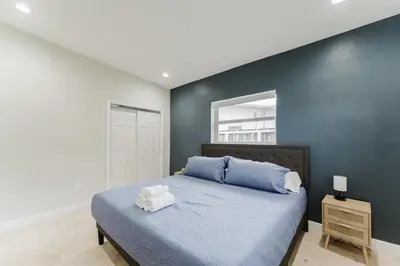 a bedroom with a bed with a blue wall at Beautiful Aventura Villa Sleeps 26 in Miami