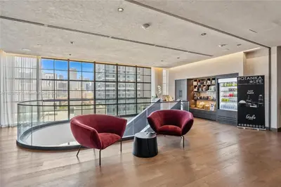 a lobby with two red chairs and a counter at Panoramic Ocean View 3 bedroom Nativo Pool Gym SPA in Miami