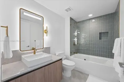 a bathroom with a sink and a tub and a toilet at Panoramic Ocean View 3 bedroom Nativo Pool Gym SPA in Miami