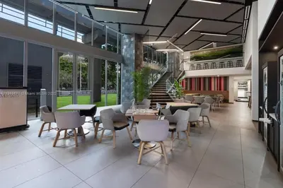 a restaurant with tables and chairs and a staircase at Ocean View Entire Condo In Downtown With Pool and Gym in Miami