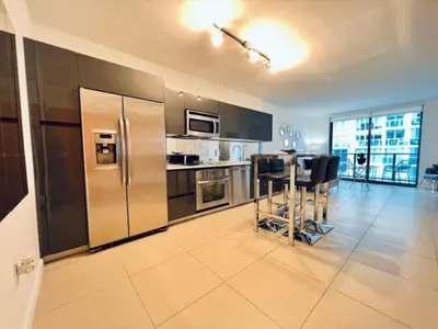 a kitchen with stainless steel appliances and a table with chairs at Miami Oasis in Brickell (3 Week Minimum) in Miami