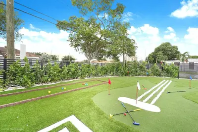 a playground with a white surfboard on the grass at The Rock & Rhythm Villa Miami Downtown - Playground,Mini Golf, BBQ, Garden Relaxation in Miami