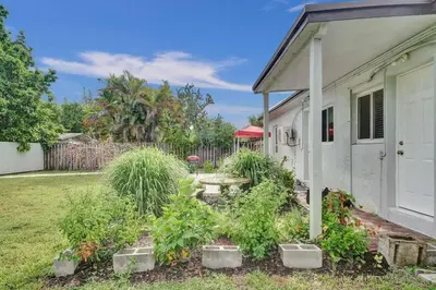 a yard with a white house and some plants at Explorer's Retreat Villa in Miami
