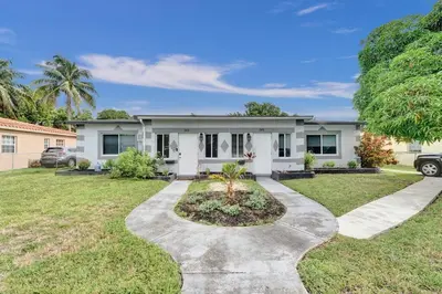 a large white house with a driveway at Explorer's Retreat Villa in Miami