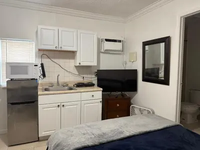 a small kitchen with white cabinets and a sink at My Garden in Miami Florida in Palmetto Bay