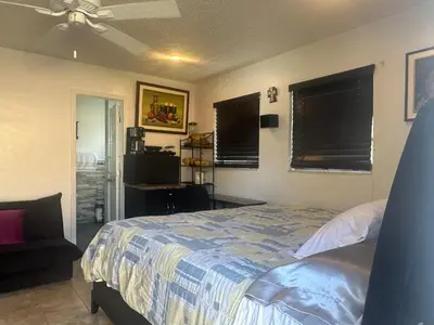 a bedroom with a bed and a chair and windows at My Garden in Miami Florida in Palmetto Bay