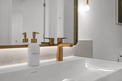 a bottle of soap sitting on a bathroom sink at Stylish City Getaway with Pool Skyline Views in Miami