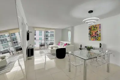 a living room with a glass table and a couch at Bay View Condo, Sleeps 6, Pool, Spa, Gym and Games in Miami