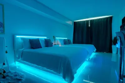 a bedroom with a bed with blue lights on it at Modern Studio with Balcony, Pool, Gym and Games in Miami