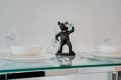 a figurine on a glass table with plates and glasses at Modern Studio with Balcony, Pool, Gym and Games in Miami