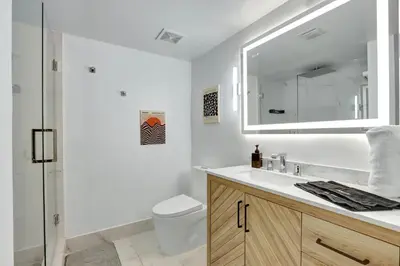 a bathroom with a sink and a toilet and a mirror at Fall in love with Brickell - Your Miami home in Miami