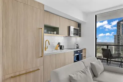 a living room with a couch and a kitchen with a view at Luxury 45th-Floor Condo with Stunning City Views in Miami