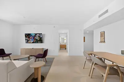 a living room with white walls and tables and chairs at Luxury 45th-Floor Condo with Stunning City Views in Miami