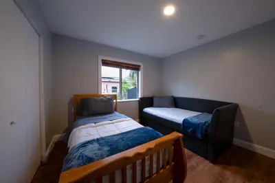 a bedroom with a bed and a couch and a window at House Genesis in Homestead