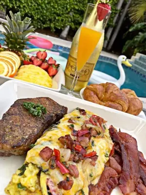a table topped with three plates of breakfast foods at Sunset Oceanfront Retreat in Hollywood