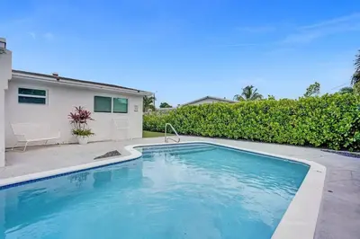 a swimming pool in front of a house at Coastal Breeze Retreat in Pembroke Pines