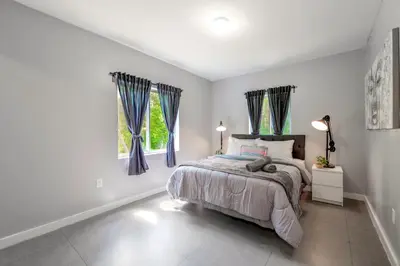 a bedroom with a bed and two windows at Spacious East Miami Duplex Delightful in Miami