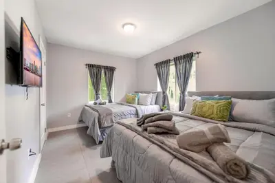 a bedroom with two beds and a television in it at Spacious East Miami Duplex Delightful in Miami
