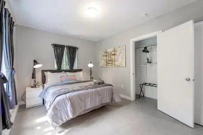 a bedroom with a large bed and a walk in shower at Spacious East Miami Duplex Delightful in Miami