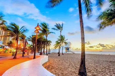 a beach with palm trees and a street light at Beachside Parking - Las Olas, Airport, Port Evg in Fort Lauderdale