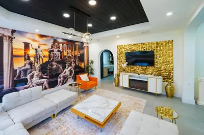 a living room with a couch and a fireplace at Casa Olympus Fort Lauderdale - Walk to the Beach! in Fort Lauderdale