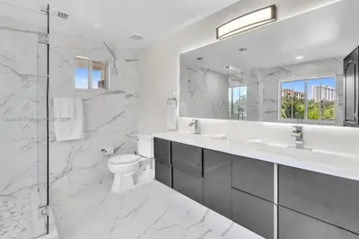 a bathroom with a toilet and a sink and a mirror at Casa Olympus Fort Lauderdale - Walk to the Beach! in Fort Lauderdale