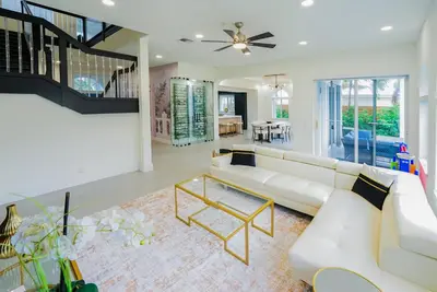 a living room with a white couch and a table at Casa Olympus Fort Lauderdale - Walk to the Beach! in Fort Lauderdale