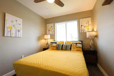 a bedroom with a yellow bed with a window at Walk to Stadium - 3BR King Bed Haven - Parking in Miami Gardens