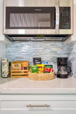 a kitchen counter with a microwave and some food at 3-Bedroom Villa with Heated Pool and Tropical Yard in Hollywood Lakes in Hollywood