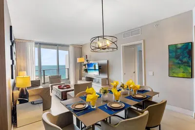 a dining room and living room with a table and chairs at On the Beach, Ocean and City Views 17 Zen at LYFE Resort in Hollywood