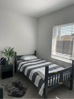 a bedroom with a bed and a window at HOSTEL Star in Hallandale Beach