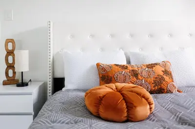 a large orange pillow sitting on a bed at Plumeria Housing in Fort Lauderdale